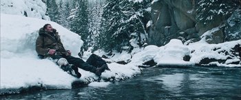 Movie still from “The Grey” (2011), directed by Joe Carnahan – A man is jumping into a river in the snow; Wide shot, High angle