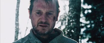 Movie still from “The Grey” (2011), directed by Joe Carnahan – A person wearing a sweater with a scar on his face; Close Up shot, Low angle