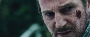 Movie still from “The Grey” (2011), directed by Joe Carnahan – A man's face with a lot of dirt on his face; Close Up shot, Over the shoulder angle