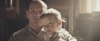 Movie still from “The Grey” (2011), directed by Joe Carnahan – A man and a boy are looking at the camera; Close Up shot, Over the shoulder angle