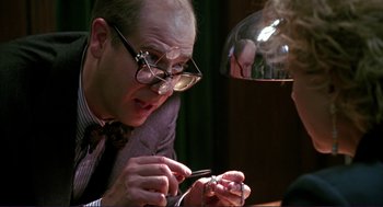 Movie still from “The Grifters” (1990), directed by Stephen Frears – A man wearing glasses looking at a woman's ring; Close Up shot, Over the shoulder angle