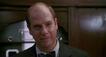 Movie still from “The Grifters” (1990), directed by Stephen Frears – A man in a suit and bow tie; Close Up shot, Over the shoulder angle