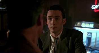 Movie still from “The Grifters” (1990), directed by Stephen Frears – A man in a suit looking at a man in a suit; Close Up shot, Over the shoulder angle