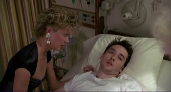 Movie still from “The Grifters” (1990), directed by Stephen Frears – A man laying in a hospital bed next to a woman; Medium shot, Over the shoulder angle