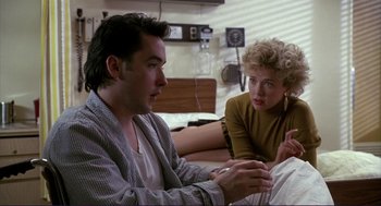Movie still from “The Grifters” (1990), directed by Stephen Frears – A man and a woman sitting in a hospital bed; Medium shot, Over the shoulder angle