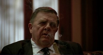 Movie still from “The Grifters” (1990), directed by Stephen Frears – A person wearing a suit and tie; Close Up shot, Low angle