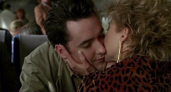 Movie still from “The Grifters” (1990), directed by Stephen Frears – A man and a woman kissing each other on the cheek; Close Up shot, Over the shoulder angle