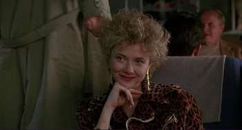 Movie still from “The Grifters” (1990), directed by Stephen Frears – A woman sitting in a chair with her hand on her chin; Close Up shot, Over the shoulder angle
