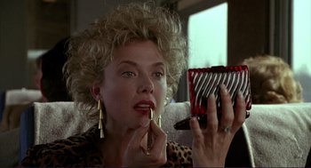 Movie still from “The Grifters” (1990), directed by Stephen Frears – A woman is putting lipstick on her lips; Close Up shot, Low angle
