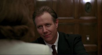 Movie still from “The Grifters” (1990), directed by Stephen Frears – A person wearing a suit and tie; Close Up shot, Over the shoulder angle