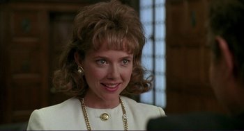 Movie still from “The Grifters” (1990), directed by Stephen Frears – A person wearing a suit and a necklace; Close Up shot, Over the shoulder angle