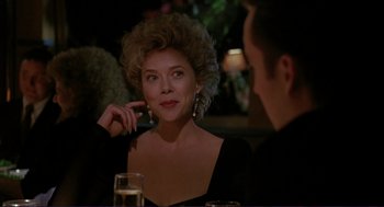 Movie still from “The Grifters” (1990), directed by Stephen Frears – A woman sitting at a table with a glass of wine; Close Up shot, Over the shoulder angle