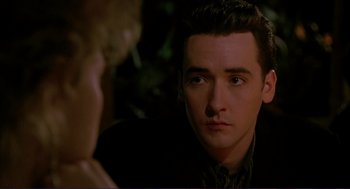 Movie still from “The Grifters” (1990), directed by Stephen Frears – A man in a black jacket is looking at a woman; Close Up shot, Over the shoulder angle