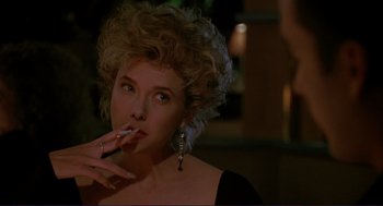 Movie still from “The Grifters” (1990), directed by Stephen Frears – A woman smoking a cigarette in a dark room; Close Up shot, Over the shoulder angle