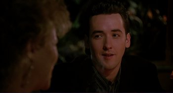 Movie still from “The Grifters” (1990), directed by Stephen Frears – A person sitting in front of another person; Close Up shot, Over the shoulder angle