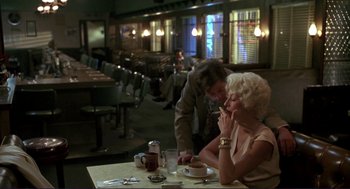 Movie still from “The Grifters” (1990), directed by Stephen Frears – An older woman sitting at a table with a man; Medium shot, Over the shoulder angle