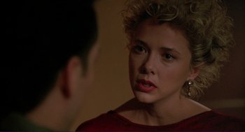 Movie still from “The Grifters” (1990), directed by Stephen Frears – A woman with curly hair is looking at a man; Close Up shot, Over the shoulder angle