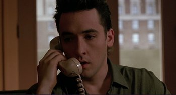 Movie still from “The Grifters” (1990), directed by Stephen Frears – A man holding a phone up to his ear; Close Up shot, High angle