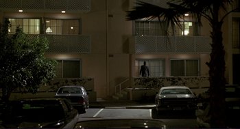Movie still from “The Grifters” (1990), directed by Stephen Frears – A person standing in a parking lot at night; Extreme Wide shot, Low angle