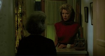 Movie still from “The Grifters” (1990), directed by Stephen Frears – A woman in a red top looking in the mirror; Medium shot, Over the shoulder angle