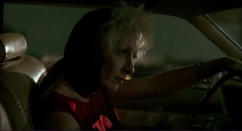 Movie still from “The Grifters” (1990), directed by Stephen Frears – A woman sitting in the driver's seat of a car; Close Up shot, Over the shoulder angle