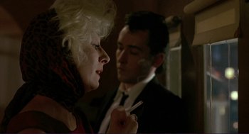 Movie still from “The Grifters” (1990), directed by Stephen Frears – A man and a woman are smoking a cigarette together; Close Up shot, Over the shoulder angle