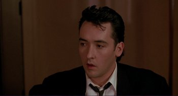 Movie still from “The Grifters” (1990), directed by Stephen Frears – A person wearing a suit and tie; Close Up shot, Low angle