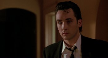 Movie still from “The Grifters” (1990), directed by Stephen Frears – A man wearing a suit and tie in front of a mirror; Close Up shot, Low angle