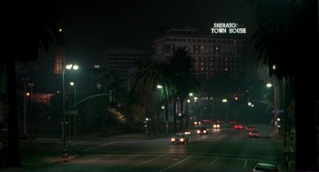 Movie still from “The Grifters” (1990), directed by Stephen Frears – A city street at night lit by street lights; Extreme Wide shot, High angle