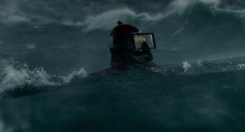 Movie still from “The Guardian” (2006), directed by Andrew Davis – A person in a helmet is in the water; Medium shot, High angle