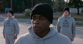 Movie still from “The Guardian” (2006), directed by Andrew Davis – A man wearing a black hat standing in a parking lot; Close Up shot, Over the shoulder angle