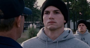 Movie still from “The Guardian” (2006), directed by Andrew Davis – A man wearing a black hat and a gray sweatshirt; Close Up shot, Over the shoulder angle