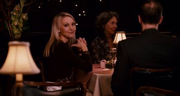 Movie still from “The Guardian” (2006), directed by Andrew Davis – A woman sitting at a table in front of two other people; Medium shot, Over the shoulder angle