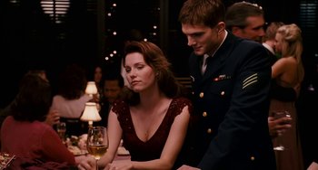 Movie still from “The Guardian” (2006), directed by Andrew Davis – A man and a woman sitting at a table with a glass of wine; Medium shot, Over the shoulder angle