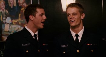 Movie still from “The Guardian” (2006), directed by Andrew Davis – Two young men in navy uniforms are laughing together; Close Up shot, Over the shoulder angle