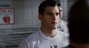 Movie still from “The Guardian” (2006), directed by Andrew Davis – A man in a white t - shirt is standing next to another man in a white t - shirt; Close Up shot, Over the shoulder angle