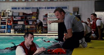Movie still from “The Guardian” (2006), directed by Andrew Davis – Two men are sitting in front of a swimming pool; Medium shot, Over the shoulder angle