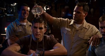 Movie still from “The Guardian” (2006), directed by Andrew Davis – A man pouring water on another man's head at a bar; Medium shot, Over the shoulder angle