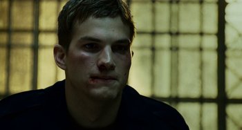 Movie still from “The Guardian” (2006), directed by Andrew Davis – A young man with a bruised face sitting next to a window; Close Up shot, Low angle