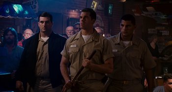 Movie still from “The Guardian” (2006), directed by Andrew Davis – A group of men standing next to each other in a room; Medium shot, Low angle