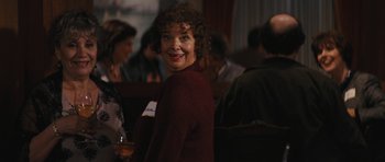 Movie still from “The Guilt Trip” (2012), directed by Anne Fletcher – A woman standing in front of a group of people; Close Up shot, Over the shoulder angle