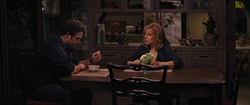 Movie still from “The Guilt Trip” (2012), directed by Anne Fletcher – Two people sitting at a table with a bowl of broccoli; Medium shot, Over the shoulder angle