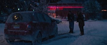Movie still from “The Guilt Trip” (2012), directed by Anne Fletcher – A man standing next to a car on a snowy street; Wide shot, Over the shoulder angle