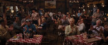 Movie still from “The Guilt Trip” (2012), directed by Anne Fletcher – A group of people sitting at tables in a restaurant; Wide shot, Over the shoulder angle