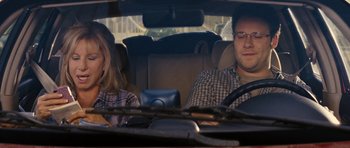 Movie still from “The Guilt Trip” (2012), directed by Anne Fletcher – A man and a woman sitting in the back seat of a car; Medium shot, Over the shoulder angle