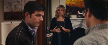 Movie still from “The Guilt Trip” (2012), directed by Anne Fletcher – A woman in a black shirt holding a book; Medium shot, Over the shoulder angle