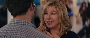 Movie still from “The Guilt Trip” (2012), directed by Anne Fletcher – A woman is smiling while holding her finger up to her ear; Close Up shot, Over the shoulder angle