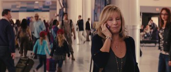 Movie still from “The Guilt Trip” (2012), directed by Anne Fletcher – A woman talking on a cell phone while walking down a sidewalk; Medium shot, Over the shoulder angle