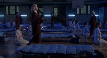 Movie still from “The Handmaid's Tale” (1990), directed by Volker Schlöndorff – A group of people standing in a room with blue mattresses; Wide shot, High angle