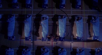 Movie still from “The Handmaid's Tale” (1990), directed by Volker Schlöndorff – An overhead view of a group of people sleeping in beds; Extreme Wide shot, Overhead angle